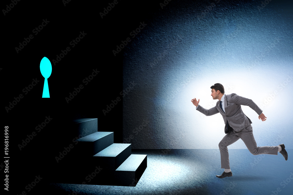 Fototapeta premium Businessman walking towards keyhole in challenge concept