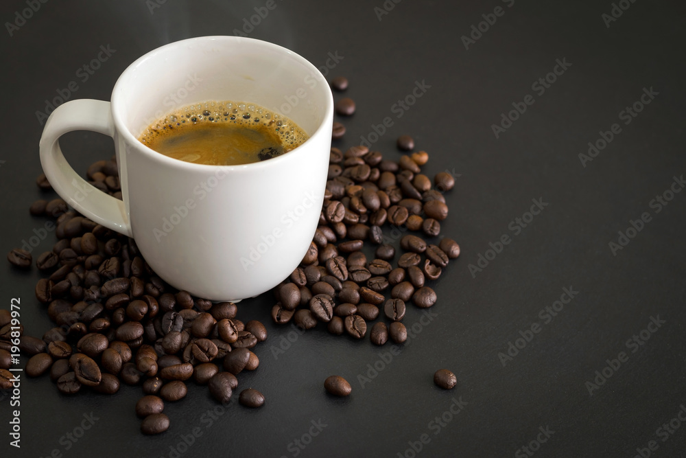 Fototapeta premium Hot coffee in white ceramic glass and coffee beans placed on the black table.