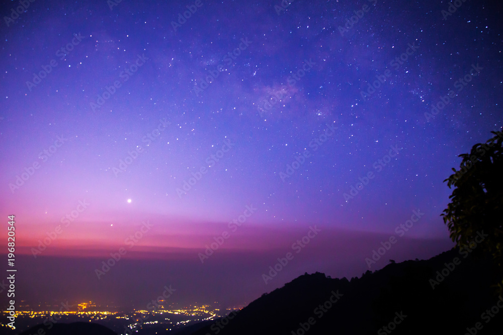 Milky way above city, twilight scene, Chiangmai, Thailand
