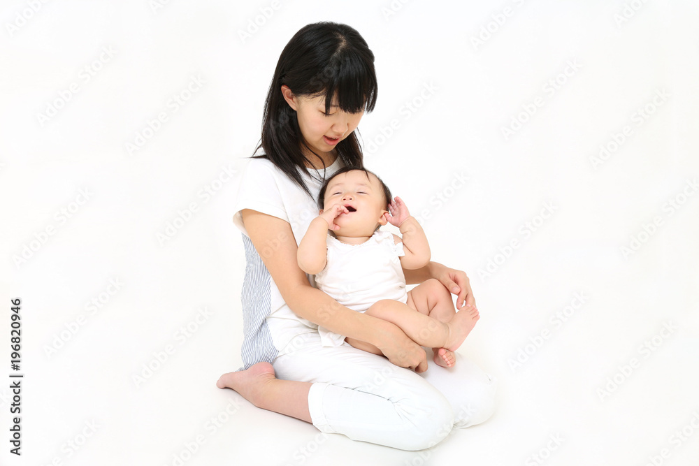 若いお母さんと遊ぶ笑顔の女の子の赤ちゃん