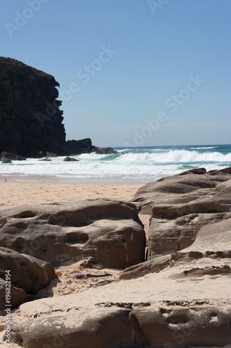Rocky outcrop at the beach on a sunny summer day © Ben Stevens