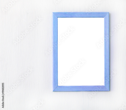 Wooden frame with blank sheet of paper on light wall. Copy space. Mock up concept