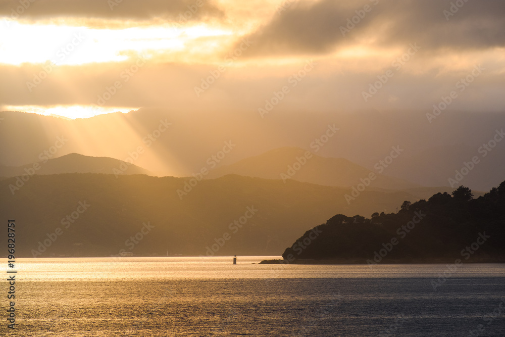 Stunning landscape sunrise  in the morning. Golden light go through the cloud to the mountain and sea.