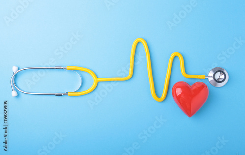 Red heart and a stethoscope on blue background photo