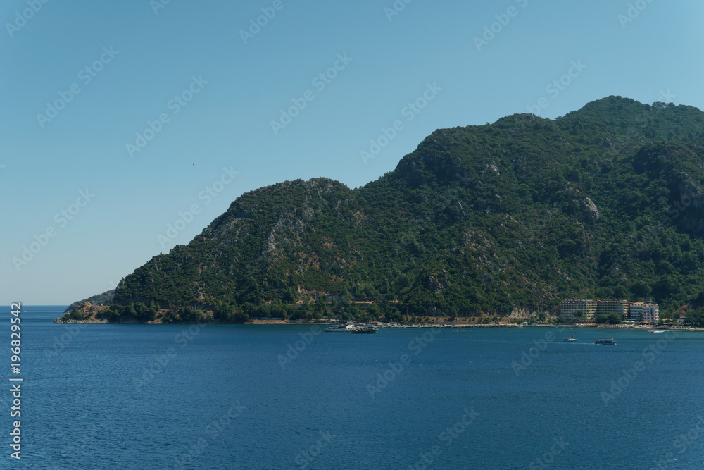Mountainous bay of the sea, hotels on the coast, boats in the bay