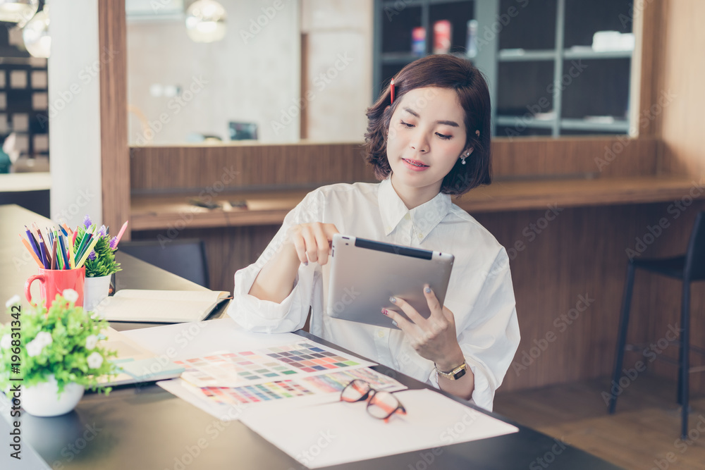 Beautiful of happy young designer woman working on desk with tablet in co working spaces. Beautiful of happy young designer woman working on desk with tablet in co working spaces.