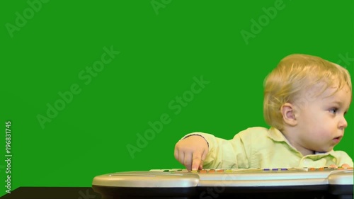 cute 1 year old baby near electronic synthesizer green screen dolly shot photo