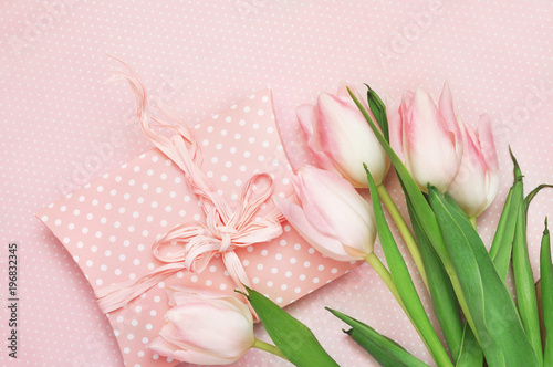 Spring blossoming tulips, festive gift on flower background, pastel and soft floral card, selective focus, toned