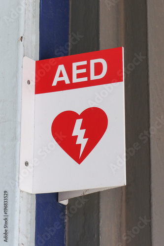 red and white Automated External Defibrillator (AED) sign in a public place