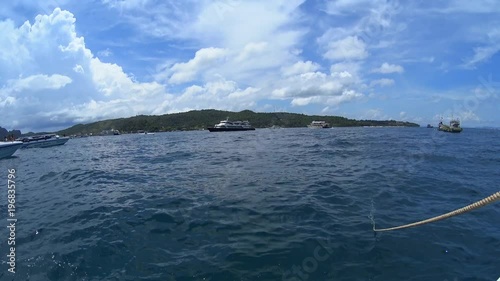 Yacht floating in the sea, sail boats on clear turquoise water, exotic islands hills on horizon 