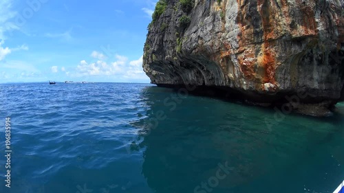 Motor boat driving around hill island, turquoise ocean water, yacht floating