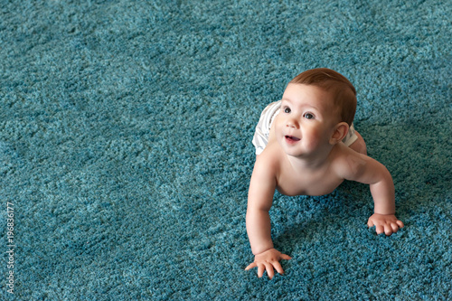 childhood, babyhood and people concept - hands of baby crawling on floor or carpet