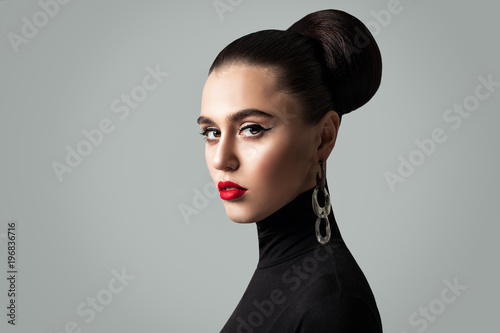 Gorgeous Woman with Perfect Hairstyle and Eyeliner Makeup. Cute Female Model Face photo