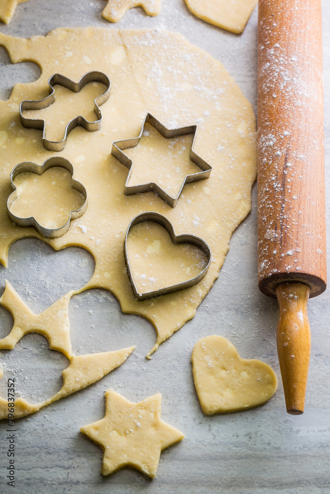 Cutting milky biscuits from fresh dough on gray table