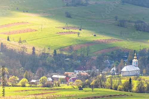 Church and village in green spring mountain valley