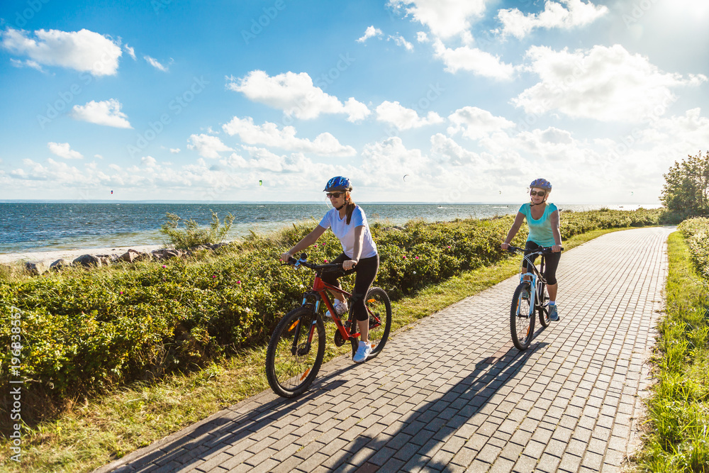 Women riding bicycles at seaside 