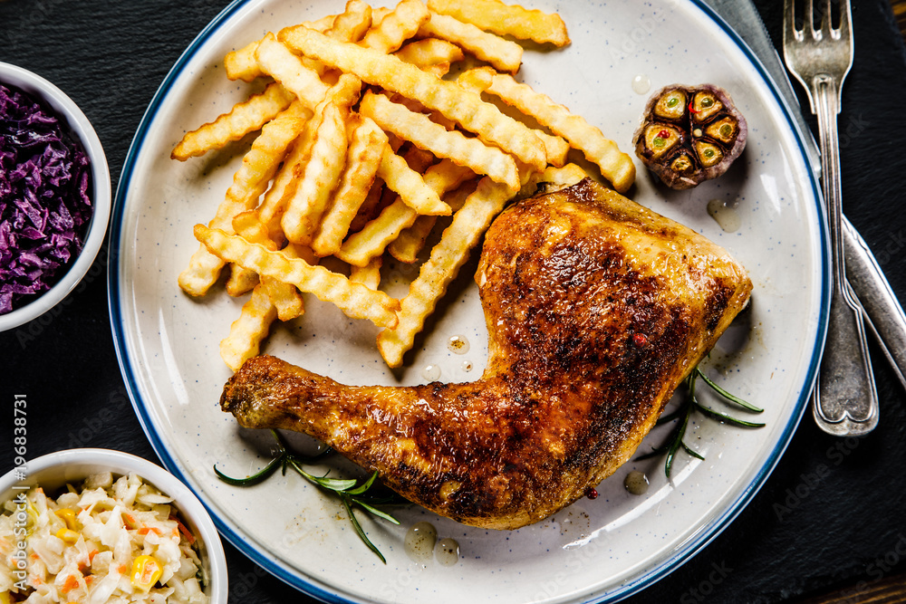 Grilled chicken legs with French fries and vegetables Grilled chicken legs with French fries and vegetables