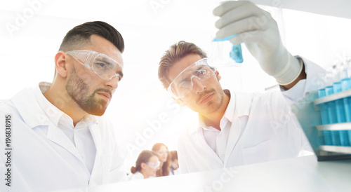 closeup. scientist and assistant studying the solution in the gl