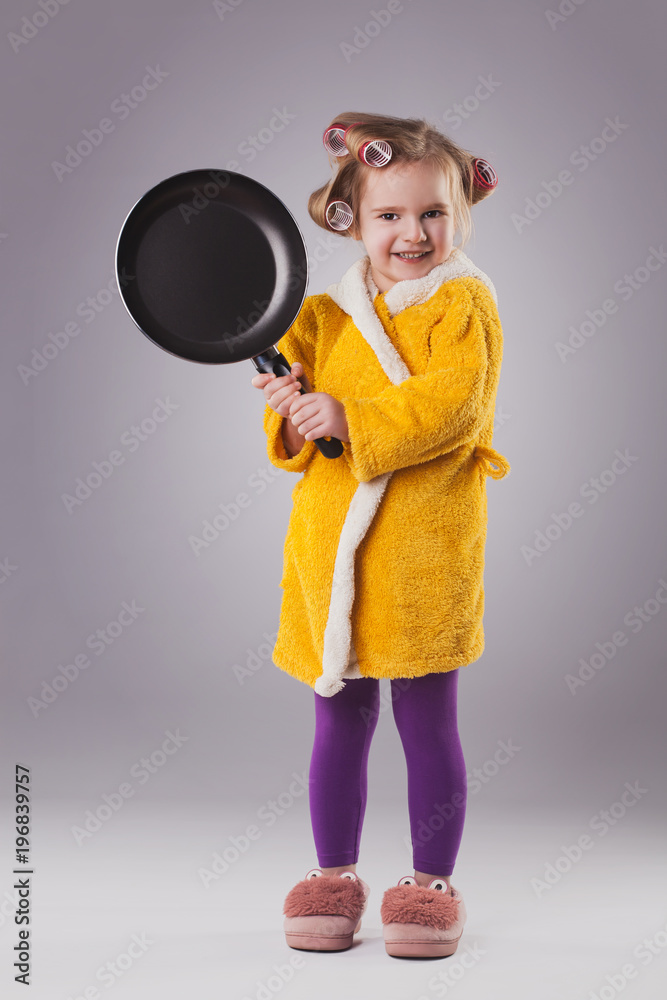 small hostess in a dressing gown with a frying pan. small hostess in a dressing gown with a frying pan.