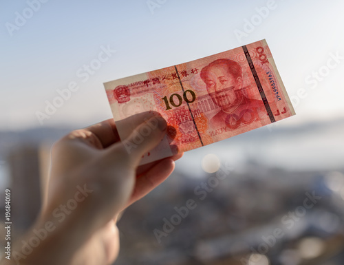100 yuan in hand. Selective focus and shallow depth of field.
