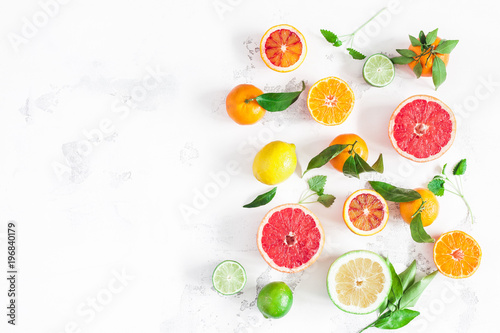 Fruit background. Colorful fresh fruits on white table. Orange  tangerine  lime  lemon  grapefruit. Flat lay  top view  copy space