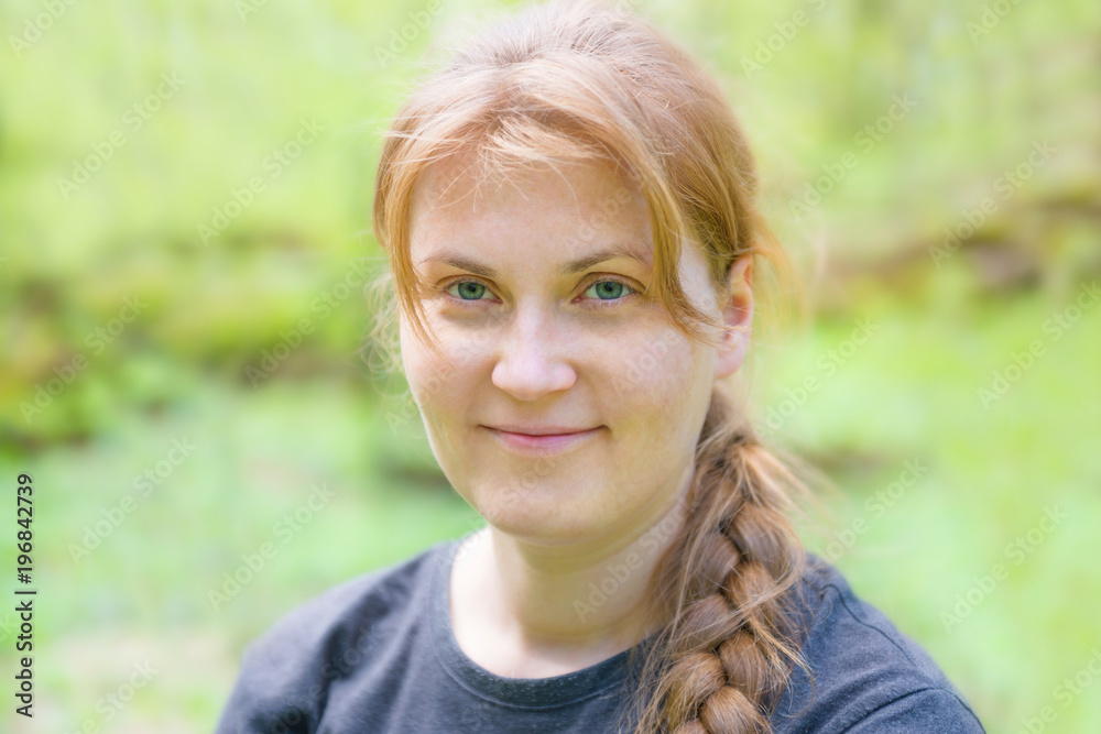 Portrait of young woman with red hair and plait in the green forest Portrait of young woman with red hair and plait in the green forest