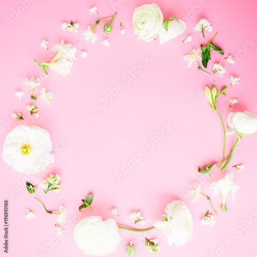 Floral round frame of white flowers on pink background. Flat lay, top view. Pastel background.
