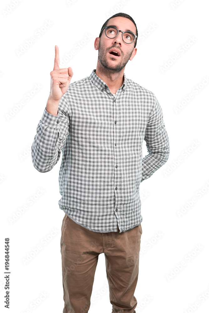 Astonished young man pointing up Astonished young man pointing up