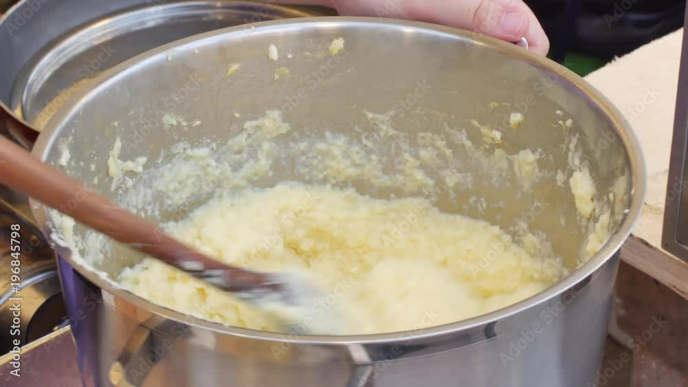 stirring a small pot of Mashed potatoes on the stove stirring a small pot of Mashed potatoes on the stove