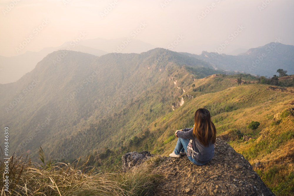 Young woman traveler sitting and looking at beautiful landscape