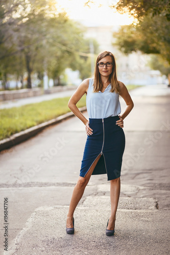 sexy woman in a pencil skirt and heels in the summer Park
