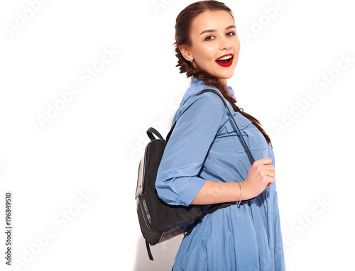Portrait of young happy smiling woman model with bright makeup and red lips with two horns in hands in summer colorful blue dress and back pack isolated on white