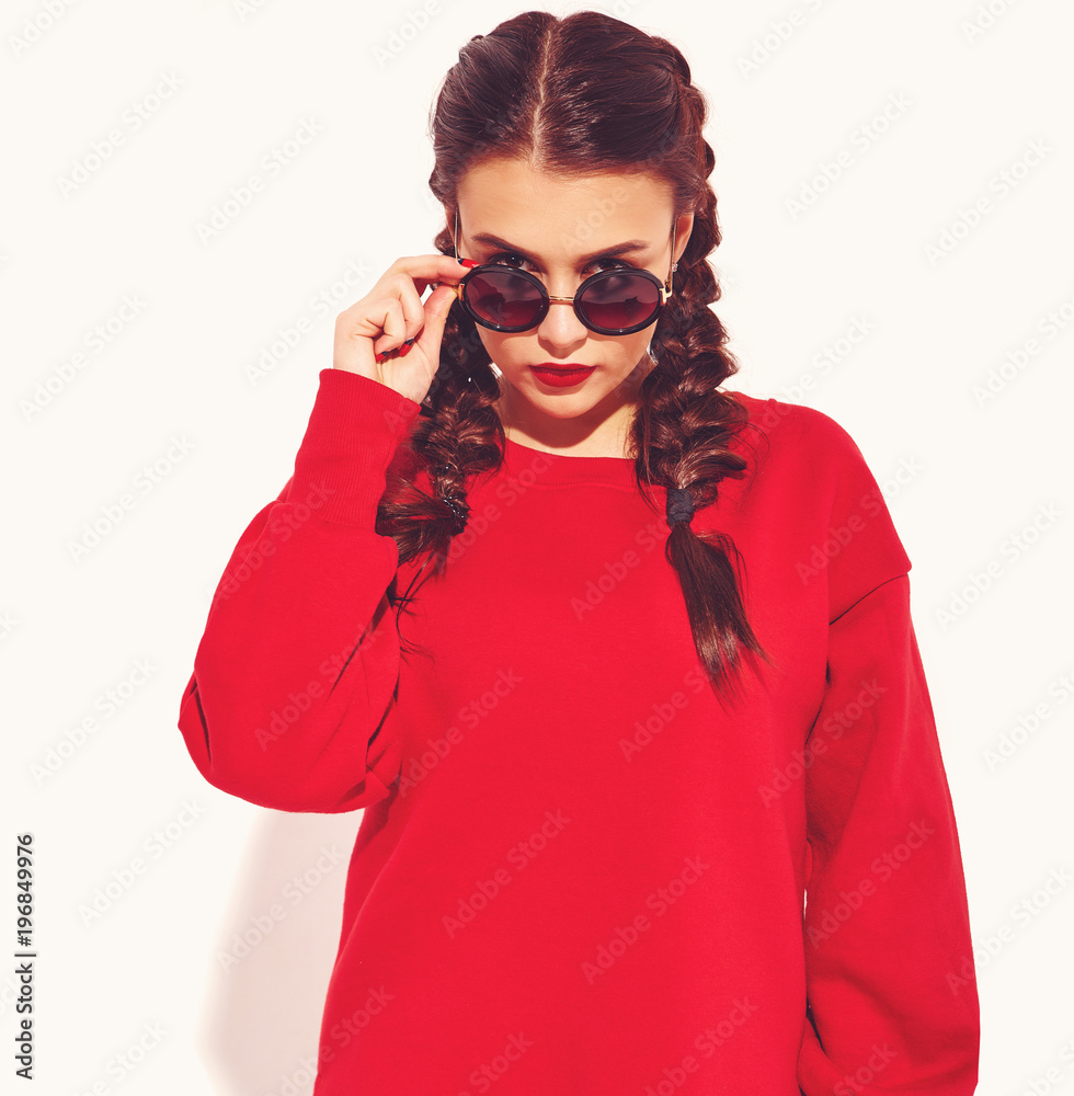 Portrait of young happy smiling woman model with bright makeup and colorful lips with two horns and sunglasses in summer red clothes isolated on white. Behind fashion sunglasses Portrait of young happy smiling woman model with bright makeup and colorful lips with two horns and sunglasses in summer red clothes isolated on white. Behind fashion sunglasses