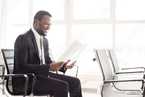 Happy elegant businessman of African-american ethnicity preparing his report for conference © pressmaster