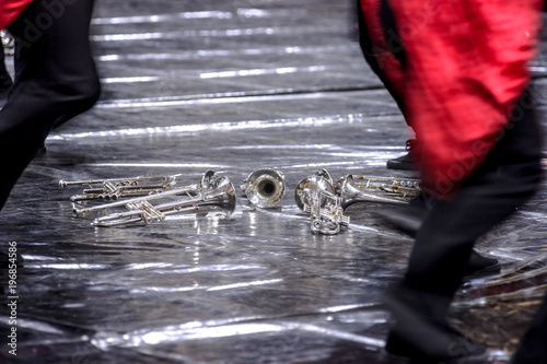 Silver colored trumpets in the hands of musicians in a performing orchestra photo