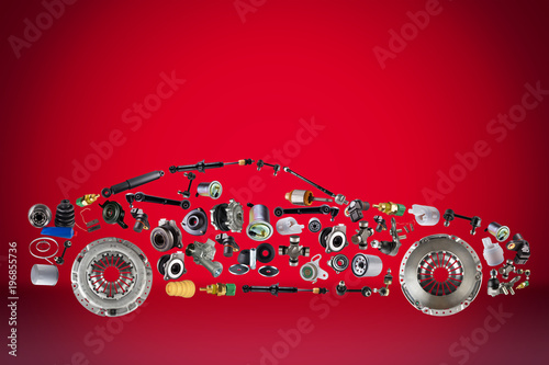 Passenger car assembled from new spare auto parts for shop aftermarket. Isolated on red background.