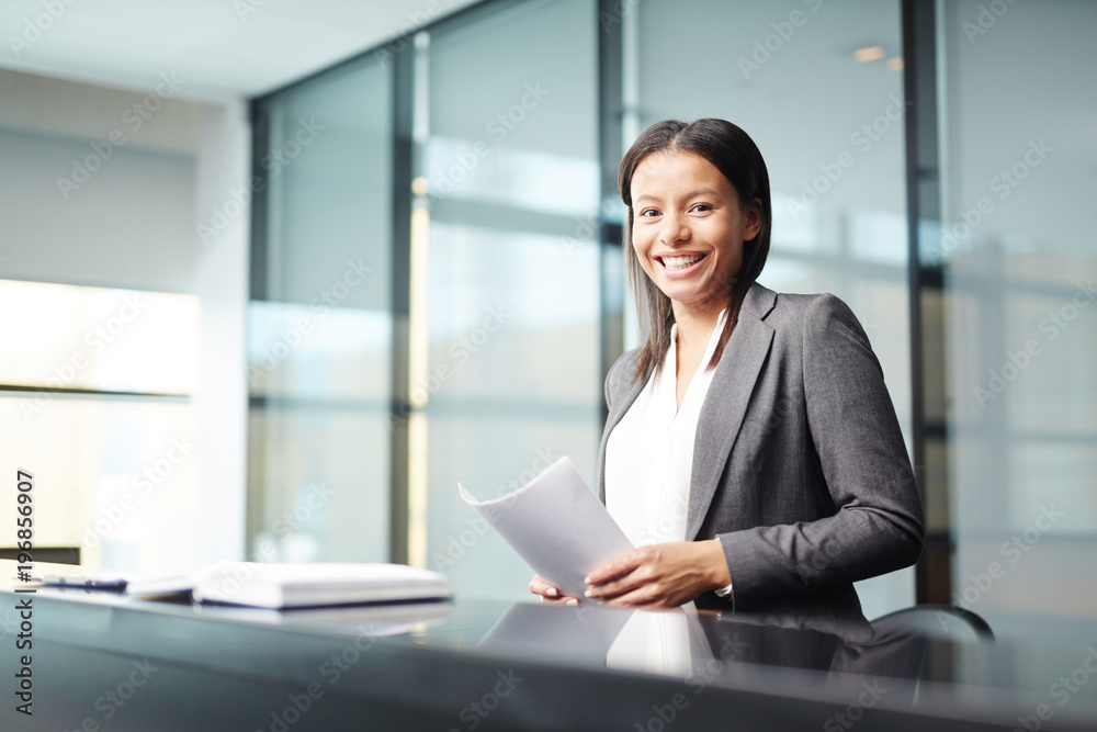 Young successful participant of conference or political delegate with papers looking at camera in conference hall Young successful participant of conference or political delegate with papers looking at camera in conference hall