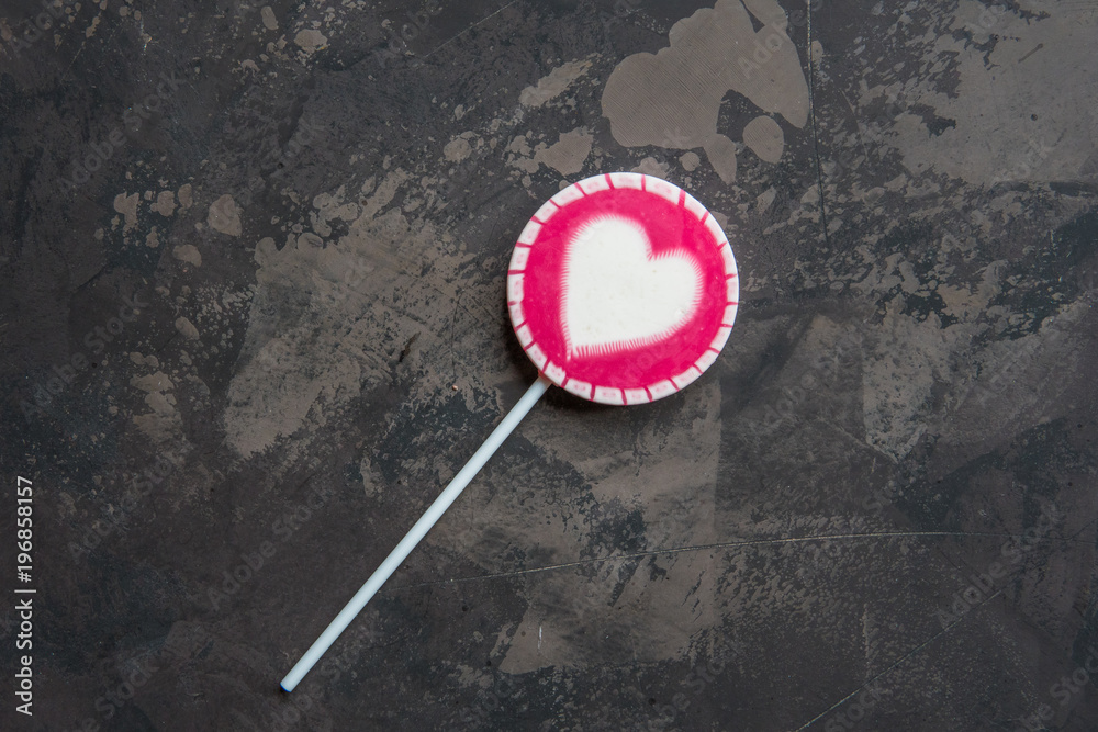 Pink lollipop with white heart top view Pink lollipop with white heart top view