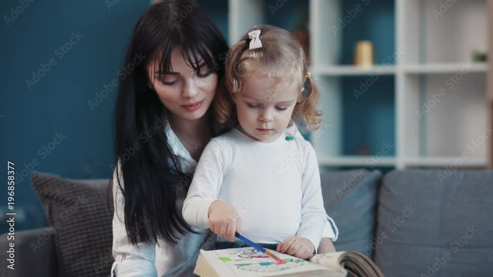 Mother sit with little daughter painting on paper together smile kid family hobby baby love person girl house coloring mom play art paintbrush childhood happy home table artist closeup portrait talk Mother sit with little daughter painting on paper together smile kid family hobby baby love person girl house coloring mom play art paintbrush childhood happy home table artist closeup portrait talk