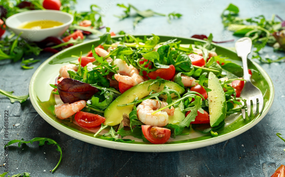 Fresh Avocado, shrimps salad with lettuce green mix, cherry tomatoes, herbs and olive oil, lemon dressing. healthy food