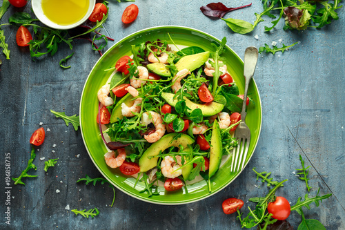 Fresh Avocado, shrimps salad with lettuce green mix, cherry tomatoes, herbs and olive oil, lemon dressing. healthy food