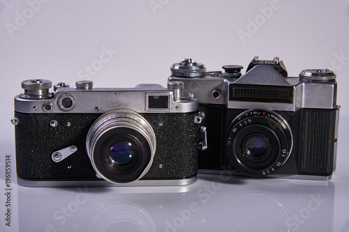 Two film cameras on a light background, which were made in the middle of the twentieth century