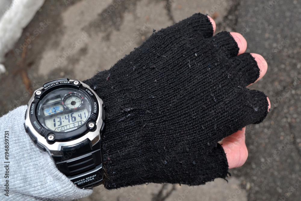 Man looking at watch. Male hand clothes by sport knitted gloves with electronic watch. Man looking at watch. Male hand clothes by sport knitted gloves with electronic watch.