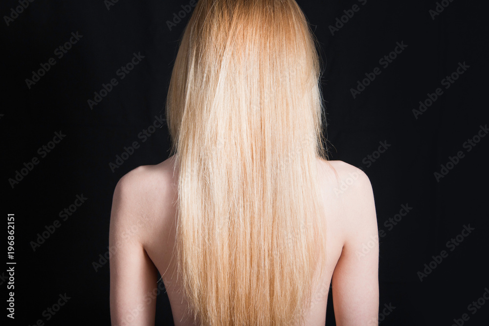 Back view of young girl with beautiful long blonde hair isolated on black  Stock Photo | Adobe Stock