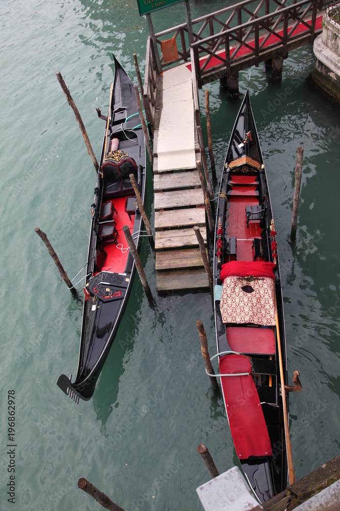View from the bridge on two gondolas at the pier in Venice