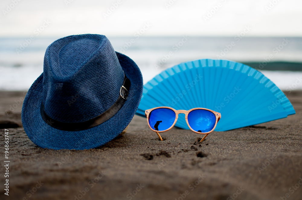 sombrero gafas y abanico en la playa