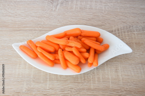 mini carrots peeled fresh on a white plate