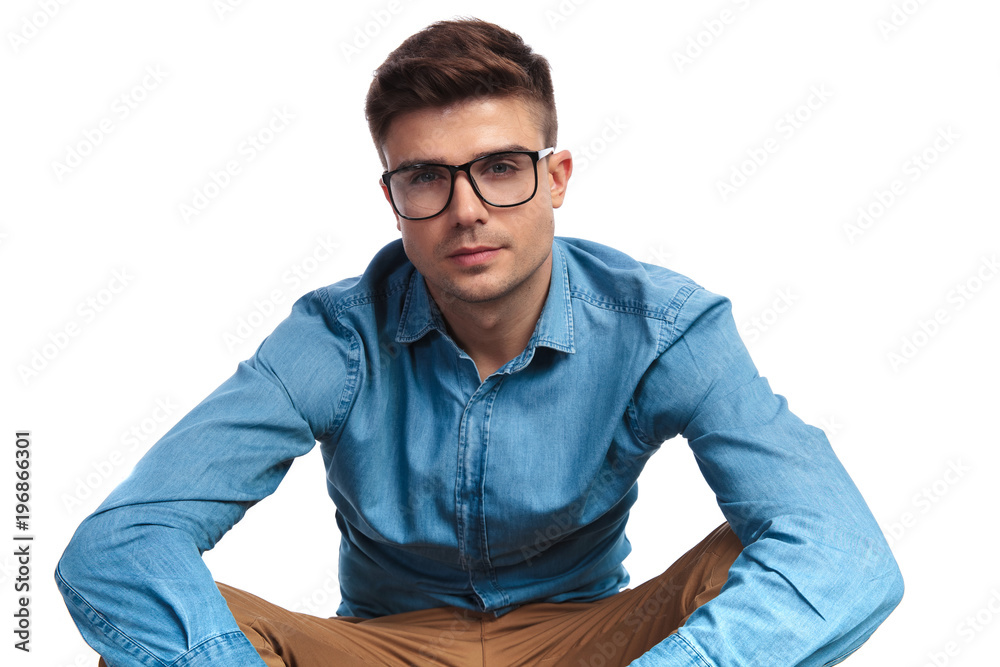 young casual man wearing glasses is sitting young casual man wearing glasses is sitting