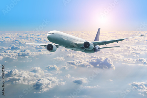 Passenger airplane flying above clouds. View from the window plane to amazing sky at the sunset. photo