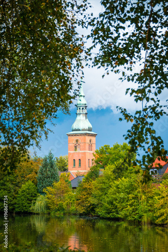 Park mit See und einer Kirche am Ufer bei sonnigem Wetter